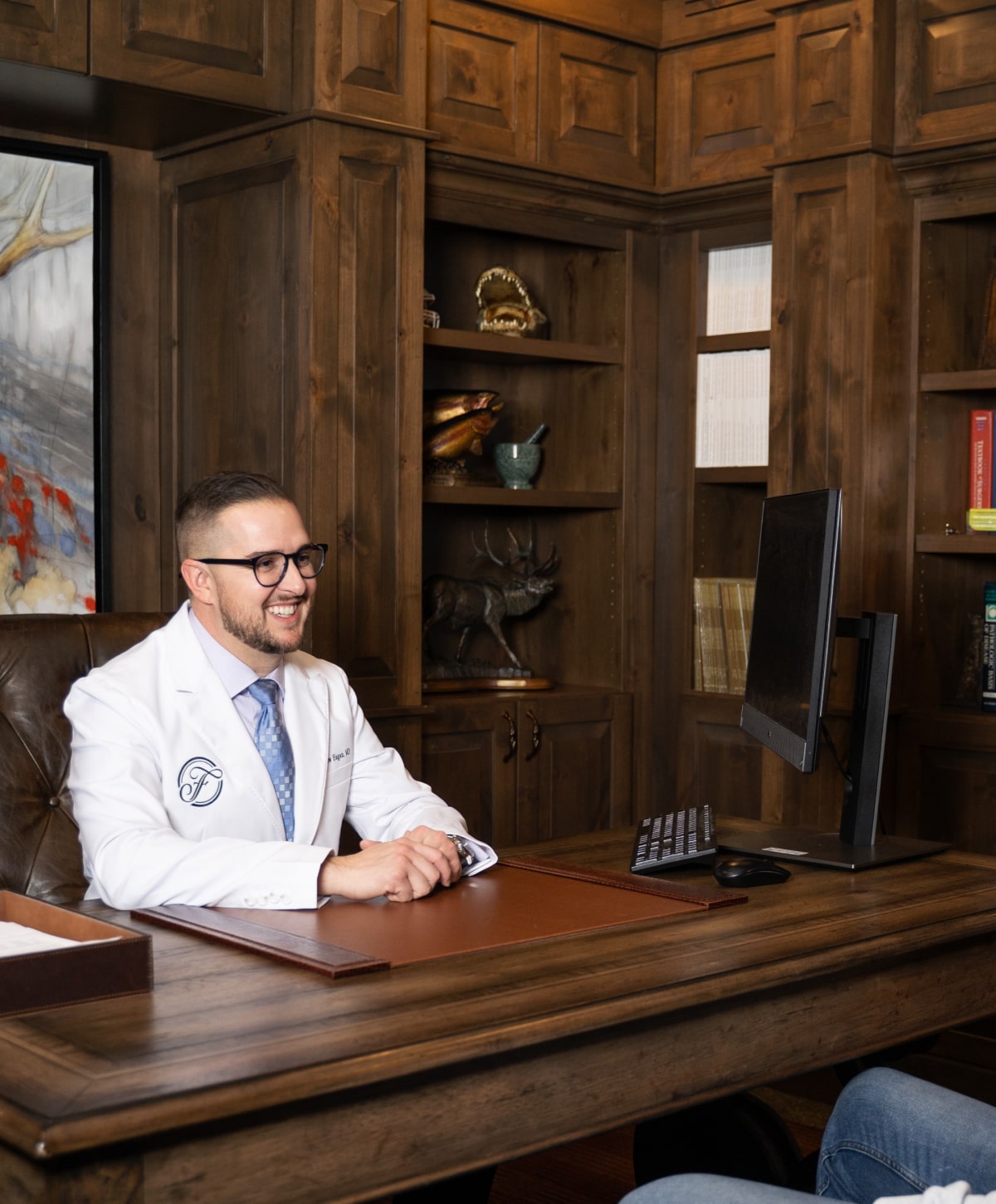 Reading Gynecomastia Surgeon Dr. Matthew Hagan sitting at desk