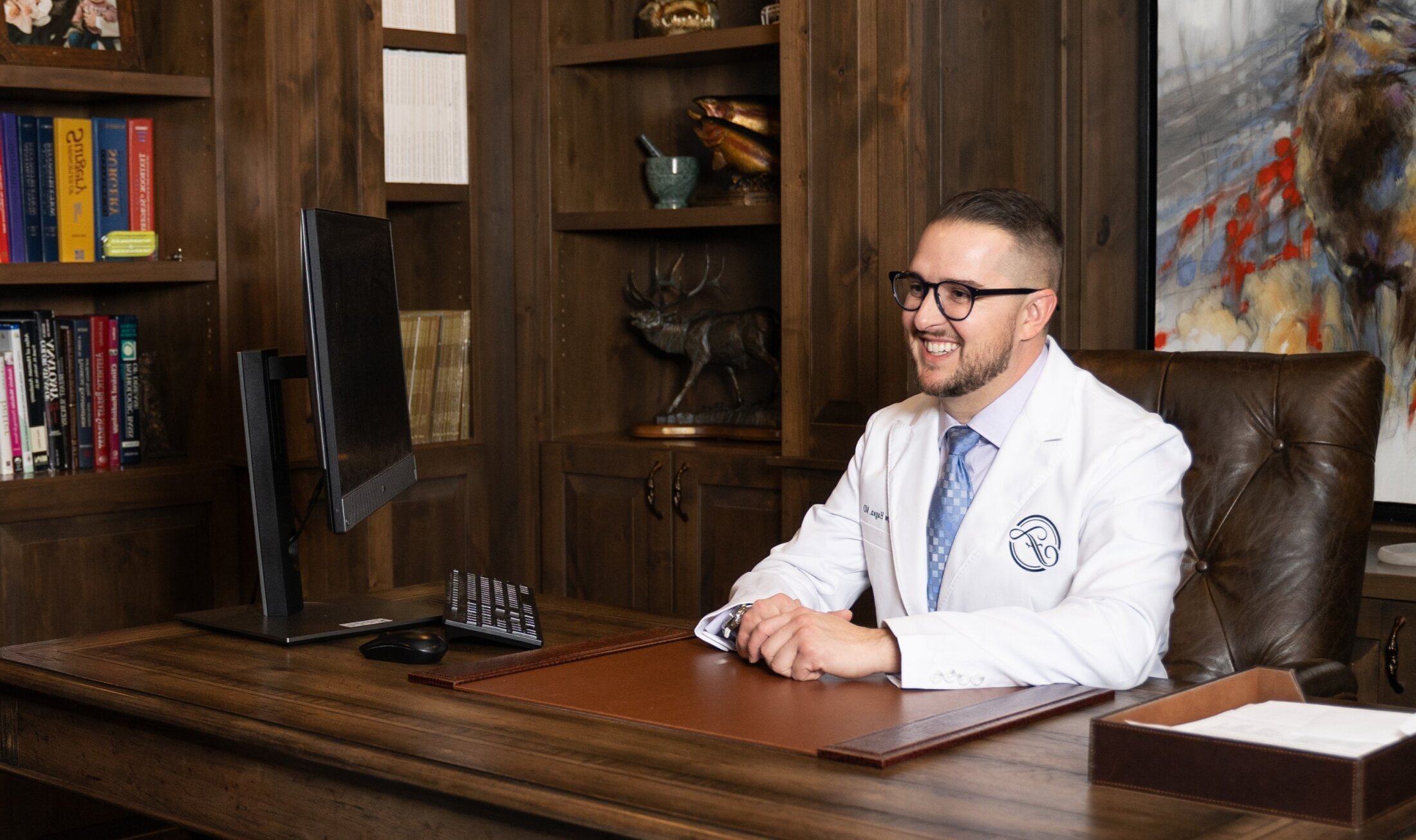 Reading Plastic Surgeon Dr. Matthew Hagan sitting at his desk